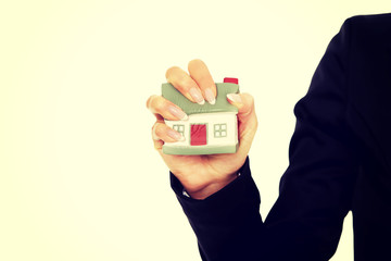 Model house is crushed in the woman hand