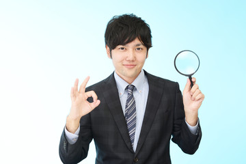拡大鏡を持つビジネスマン