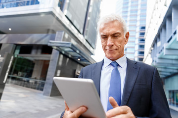 Senior businessman holding touchpad 