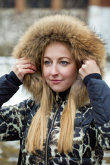 Young beautiful blonde woman in fur hood