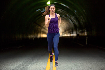 Fast run sprinter tough woman running down the street urban city background cars and tunnels