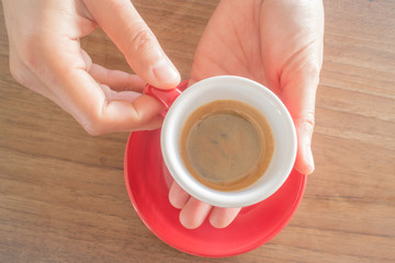 Hands holding cup of hot coffee