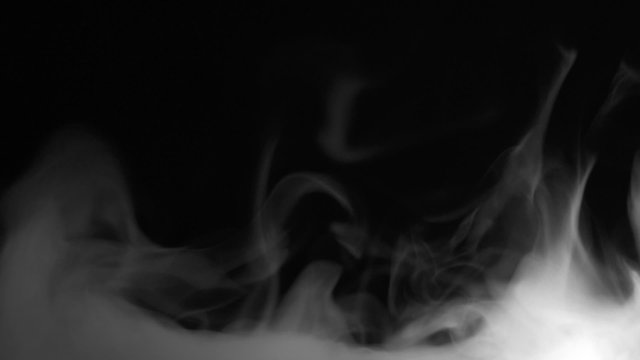 Real white steam looking like smoke isolated on black background. Clouds of fantasy smoke abstract magic mystic fog toxic gas fumes pollution. Real speed motion. Camera locked down.