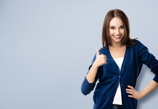 young woman showing thumbs up gesture, with copyspace