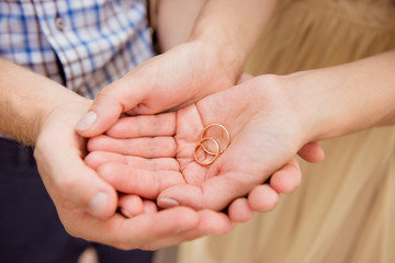 Closeup photo of a happy couple in love holding wedding rings