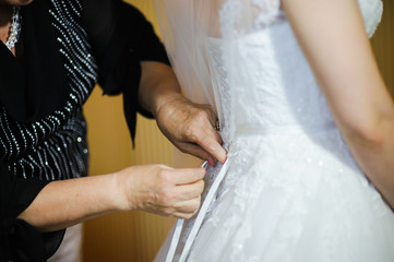 bride getting dressed on her wedding day