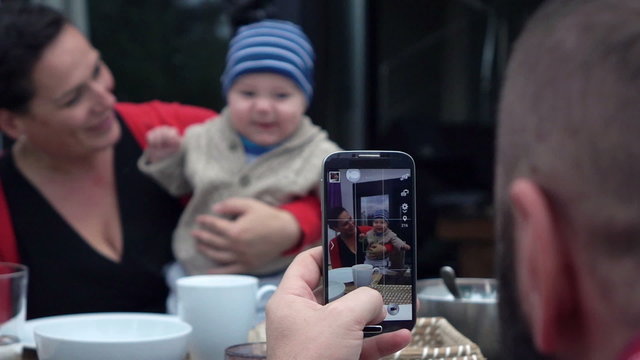 Father taking photo with cellphone of his wife and son, super slow motion
 
 
