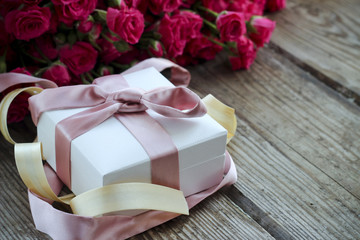 Holiday background with pink roses and gift box