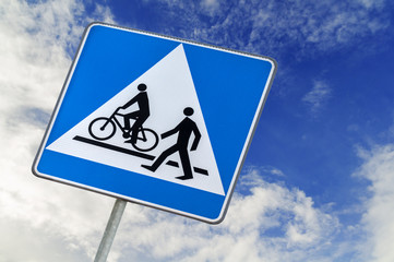 Bicycle and pedestrian road sign on blue sky, bike cycling and walking