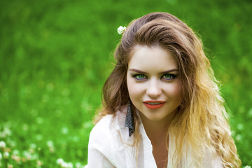 Young blonde woman on green meadow