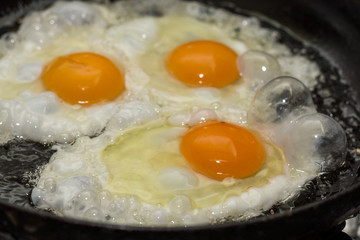 Three eggs frying in the hot oil