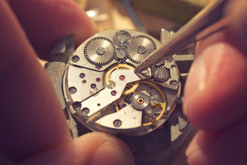 Working On A Mechanical Watch. A watch makers work top. The inside workings of a vintage mechanical...