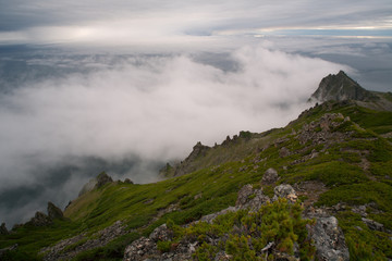 Fototapeta na wymiar Rocks over the sea in the mist. The Sea of Okhotsk. Koni peninsula. Magadan Region. Russia.