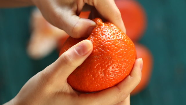 young woman peel tangerine (mandarin) 