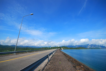 Fototapeta na wymiar road over dam with blue sky background