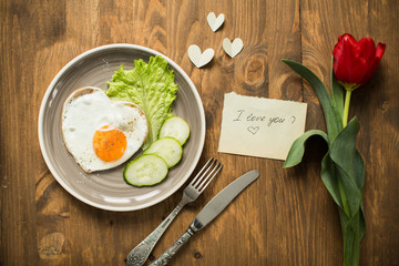on Valentine's Day, fried eggs in the shape of a heart and fresh vegetables
