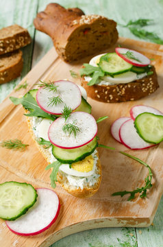Sandwiches with egg, radish, cucumber and arugula