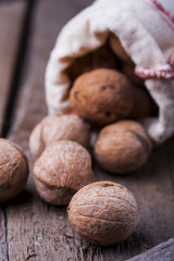 Pile of walnuts the shell on a wooden background