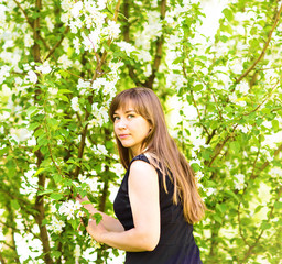 Beautiful young woman over white blossom tree, outdoors spring portrait
