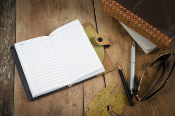 Open notepad and pencil on wood table