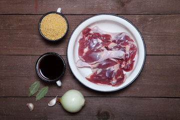 Duck legs, couscous, red wine in an enamel pot, onion, bay leaf