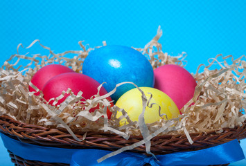 Easter eggs in a nest on blue background