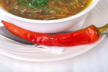 Closeup of soup and red hot pepper.
