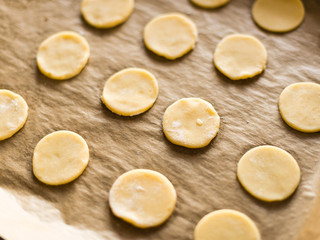 Baking cookies concept - fresh raw cookie dough on a baking tray with parchment paper - ready for baking