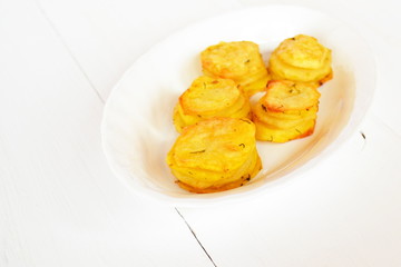 Baked potatoes with spices on a white plate
