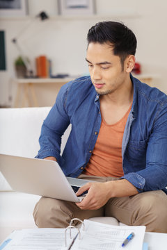 student arbeitet mit laptop und unterlagen zu hause