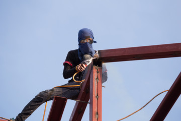 worker welding the steel to build the roof