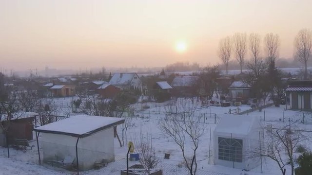 Panorama of a Village Small Houses Bare Branches Trees Sunset Pink Sky Snow is on a Ground Wintry Lanscape Winter Cloudy Sun Shines through Pink Clouds