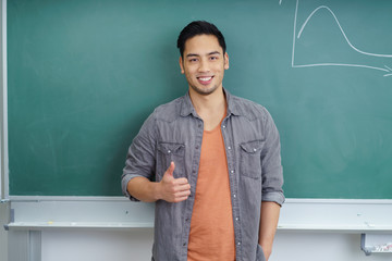 student vor der tafel zeigt daumen hoch