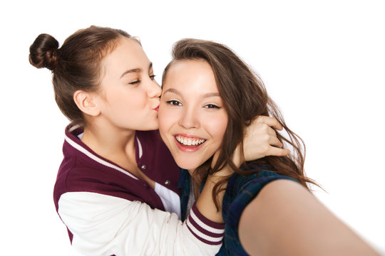 happy teenage girls taking selfie and kissing