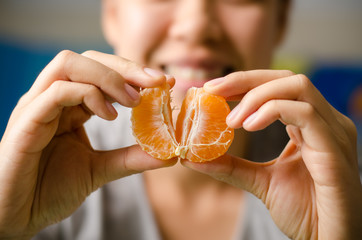 Piece of Tangerine orange hold by hand ready to eating