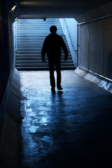 Silhouette of single person walk in the light of the end of a Tunnel.