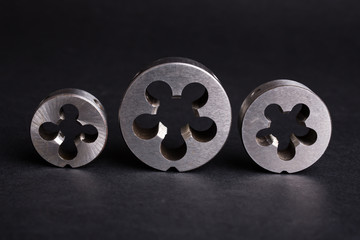 Fototapeta premium thread cutting die tool on a black background