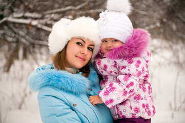 Fototapeta premium Mother and her little daughter enjoying beautiful winter day out