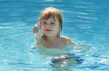 Fototapeta na wymiar little kid happy to swim in the pool