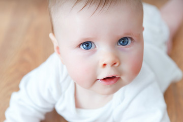 beautiful little baby on wooden floor