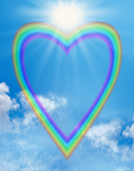 Rainbow love heart blue sky frame - a large empty rainbow shaped heart creating a frame on a blue...