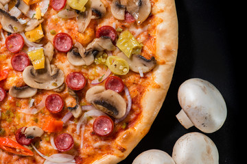 closeup Tasty pizza with tomatoes, mushroom, sausage, basil and