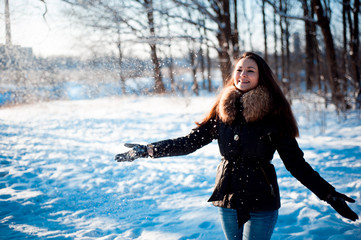 Fototapeta na wymiar Pretty girl throws snow