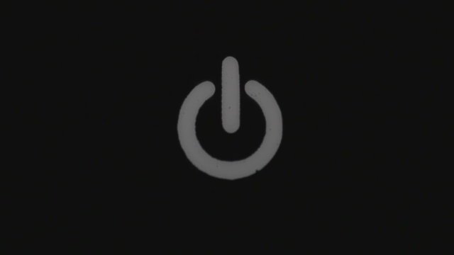 Power button turning on and off on a dark background