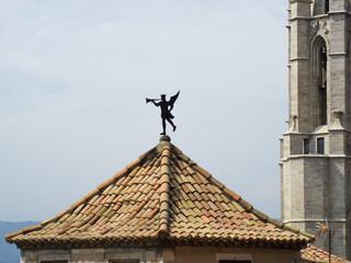 Fototapeta na wymiar The weather vane on the roof of the building. Girona, Spain.