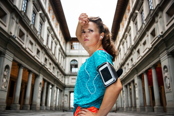Sporty woman with earphones catching breath