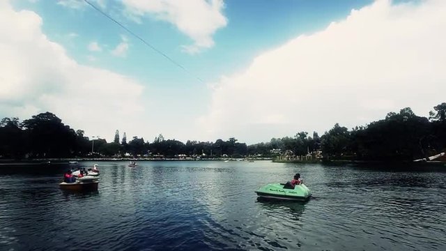 Locked-on shot of tourists riding paddle boats in a lake, Yercaud, Salem, Tamil Nadu, India