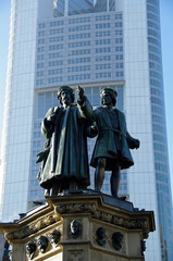 Fototapeta na wymiar Gutenberg-Denkmal in Frankfurt vor der Kulisse des Gebäudes der Commerzbank
