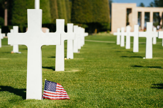 Une croix et un drapeau américain au cimetière militaire de Colleville-sur-Mer, Normandie, France.