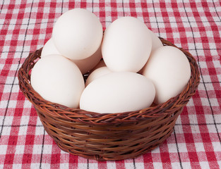 eggs in a wicker basket on  red checkered background